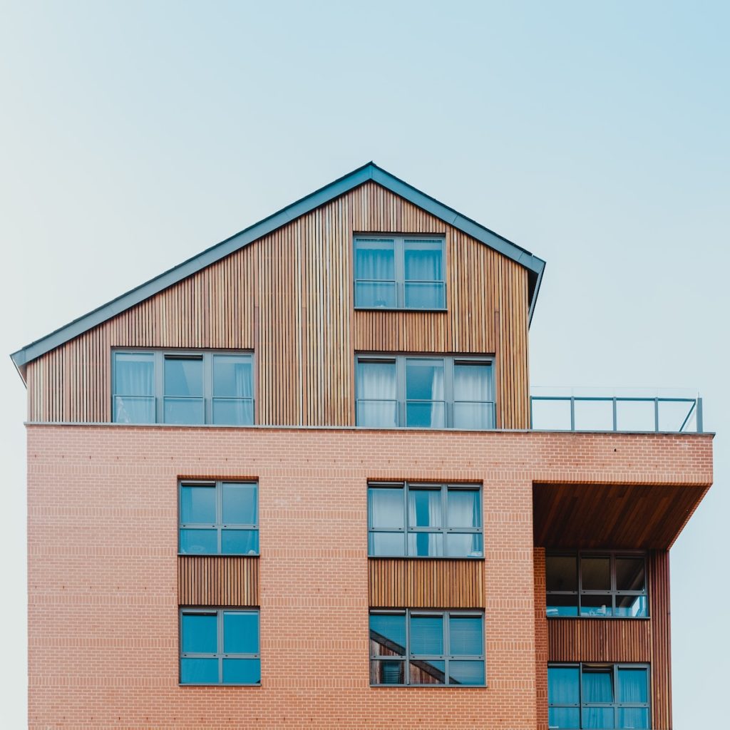Modern multi-story building with wood and brick facade against clear sky